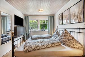 a bedroom with two beds and a television in it at Ferienwohnung Dahmlos in Kremperheide