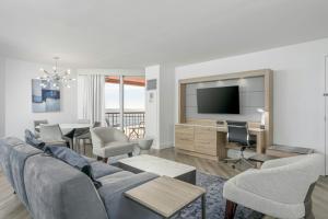a living room with a couch and a tv at Perdido Beach Resort in Orange Beach