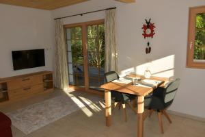 a dining room with a wooden table and chairs at Ferienwohnung am Nettenbach in Bernau im Schwarzwald