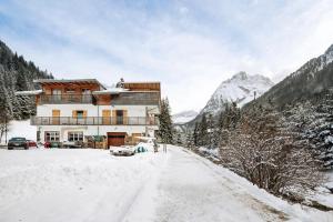 a house in the snow in the mountains at Guesthouse Canazei Cozy 2-Bedrooms in Canazei