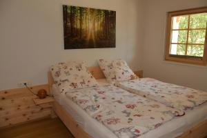a bed in a bedroom with a picture on the wall at Ferienwohnung am Nettenbach in Bernau im Schwarzwald