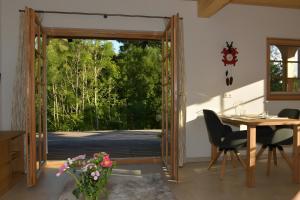 a dining room with a door open to a patio at Ferienwohnung am Nettenbach in Bernau im Schwarzwald +11 photos