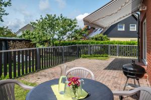 a table with a vase of flowers on a patio at Ferienwohnung An der Haferkoppel in Groß Kussewitz