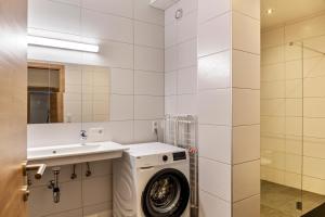 a bathroom with a washing machine and a sink at Ferienwohnung Brandbergblick in Mayrhofen