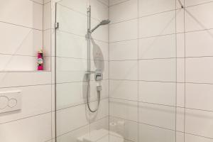 a shower with a glass door in a bathroom at Ferienwohnung Brandbergblick in Mayrhofen +12 photos