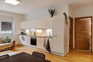 a kitchen with white cabinets and a table at Ferienwohnung Brandbergblick in Mayrhofen
