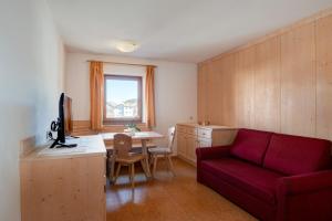 a living room with a red couch and a table at Apartment 7 - Zur Sonne in Laion