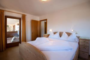 a bedroom with a large white bed with a balcony at Apartment 7 - Zur Sonne in Laion