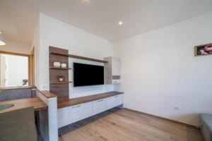 a living room with a tv on a wall at City Apartment Flora in Merano
