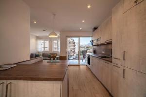 a kitchen with wooden cabinets and a living room at City Apartment Flora in Merano
