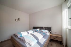 a bedroom with a bed and a wooden nightstand at City Apartment Flora in Merano