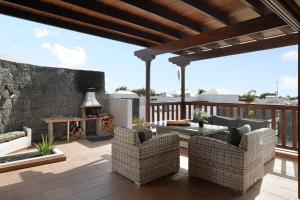 a patio with chairs and a table and a fireplace at Villa Peaky in Yaiza