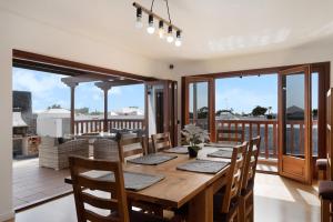 a dining room with a table and chairs and a balcony at Villa Peaky in Yaiza