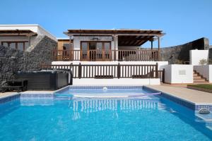 a swimming pool in front of a house at Villa Peaky in Yaiza