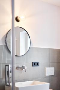 a bathroom with a sink and a mirror at Alte Seifensiederei - Fabienne in Bad Tölz