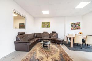 a living room with a leather couch and a table at Menzel Ferienwohnungen - W3 in Beckingen