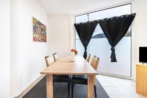 a dining room with a wooden table and chairs at Menzel Ferienwohnungen - W3 in Beckingen