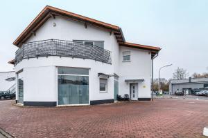 a white building with a balcony on top of it at Menzel Ferienwohnungen - W3 in Beckingen