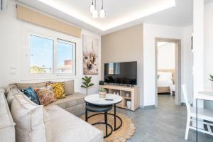 a living room with a couch and a tv at Velvet Apartments in Rhodes Town