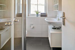 a white bathroom with a sink and a shower at Wohnung 2 in Wallhausen
