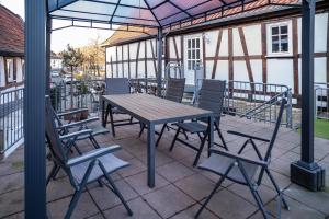 a picnic table and chairs under an umbrella on a patio at Wohnung 2 in Wallhausen
