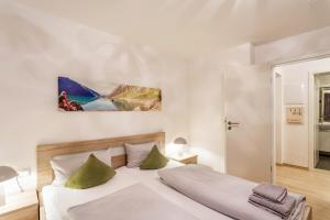 a bedroom with a large white bed with green pillows at Ferienwohnung Viadukt in Willingen