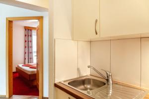 a kitchen with a sink and a bed in a room at Alpenflora 1 in Ischgl +23 photos