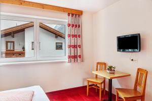 a living room with a table and a window at Alpenflora 1 in Ischgl