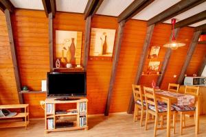 a dining room with a television and a table with chairs at Villa Königsdorf am See in Waldkirchen