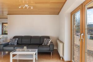 a living room with a black couch and a table at Pension Stilletal - Springstille in Springstille