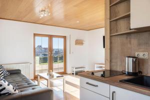 a kitchen and living room with a couch and a table at Pension Stilletal - Springstille in Springstille