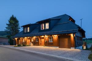 a house with a gambrel roof with a garage at Chalet Foret - Ferienwohnung in Todtnauberg