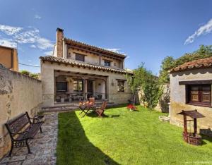 a backyard of a house with a grass yard at Villa De Urueña Casa de Ilustres in Urueña