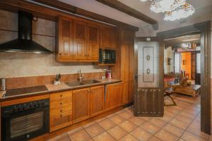 a kitchen with wooden cabinets and a sink at Villa De Urueña Casa de Ilustres in Urueña +28 photos
