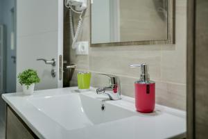 a bathroom sink with a pink soap dispenser on it at 2b El Amore in Vecindario +12 photos