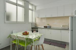 a kitchen with a table with chairs and a tableasteryasteryasteryasteryasteryastery at 2b El Amore in Vecindario