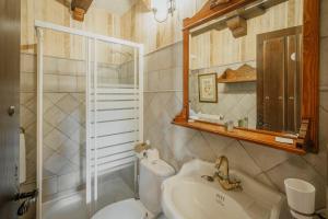 a bathroom with a sink and a toilet and a mirror at Villa De Urueña Casa de Ilustres in Urueña