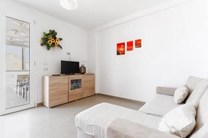 a white living room with a couch and a tv at Donasand_torre san giovanni in Torre San Giovanni Ugento