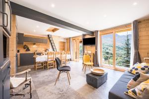 a living room with a blue couch and a kitchen at La scierie de la grande ourse in Albiez-Montrond