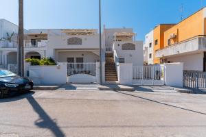 a car parked in front of a white house at Donasand_torre san giovanni in Torre San Giovanni Ugento