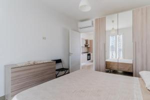 a white bedroom with a bed and a bathroom at Donasand_torre san giovanni in Torre San Giovanni Ugento
