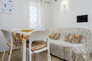 a living room with a table and a couch at Confortevole villetta caposchiera in San Teodoro