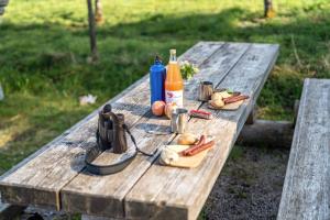 a picnic table with a bottle of alcohol and food on it at Trekking Camp am Renchtalsteig in Oppenau