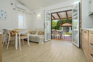 a kitchen and a dining room with a table and chairs at Confortevole villetta caposchiera in San Teodoro