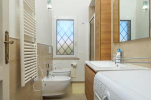 a bathroom with a sink and a toilet and a window at Confortevole villetta caposchiera in San Teodoro +12 photos