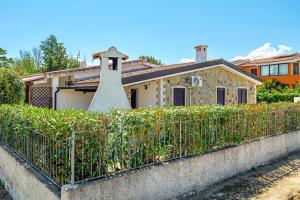 a house with a fence in front of it at Confortevole villetta caposchiera in San Teodoro