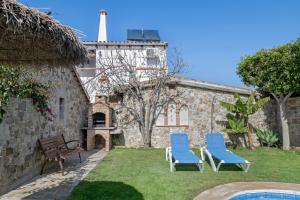 two chairs and a bench in front of a building at Casas Alfonso y Laura in Conil de la Frontera