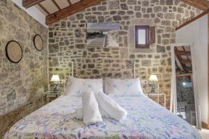 a bedroom with a bed in a stone wall at Casas Alfonso y Laura in Conil de la Frontera +38 photos