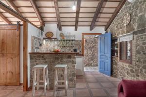 a kitchen with a blue door and stools at Casas Alfonso y Laura in Conil de la Frontera