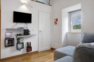 a living room with a flat screen tv on a wall at Moradia Dos Castelos Azul in Ourém